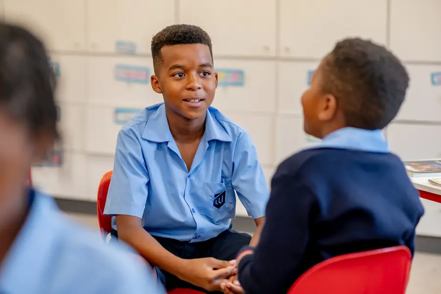 Two boys deep in conversation at their desks