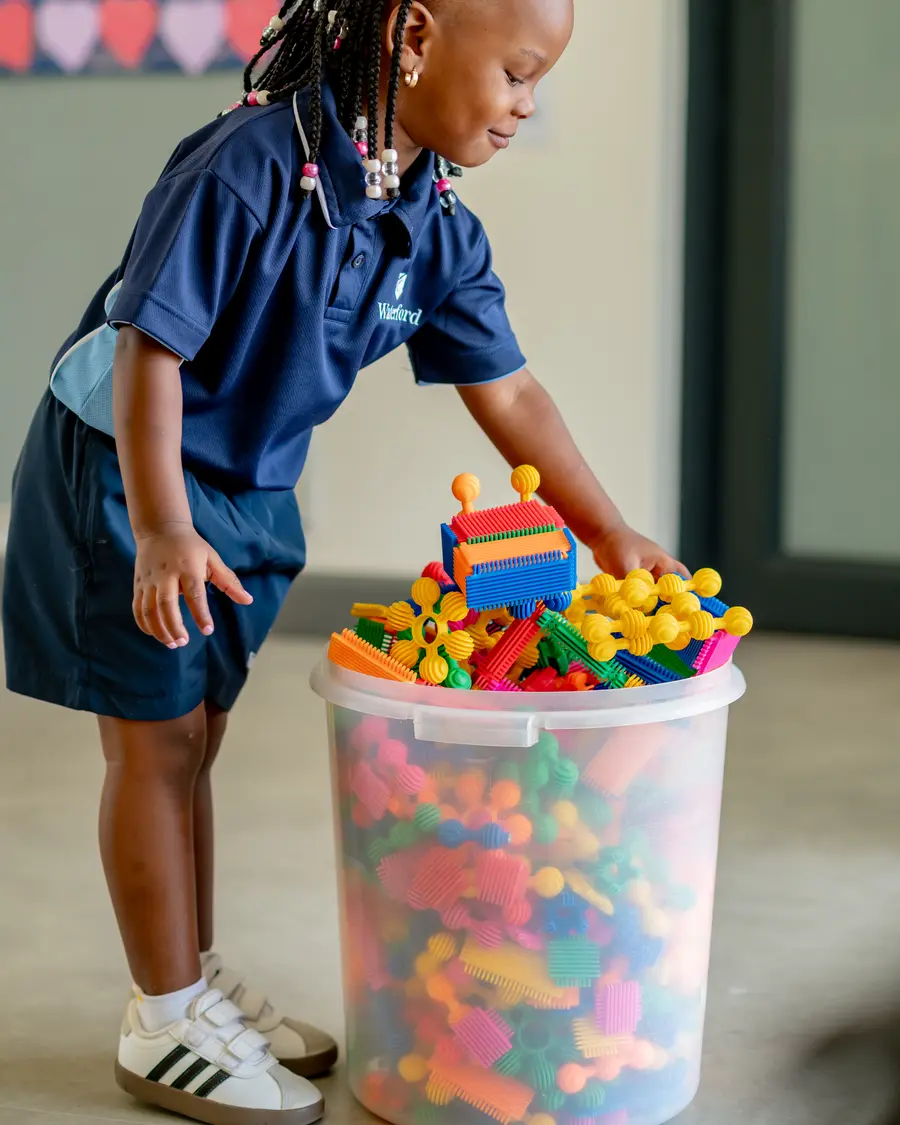 A Preschool girl building with colourful blocks