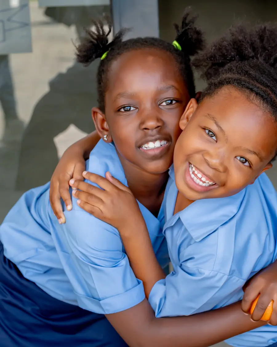 Two Preparatory School girls hugging and laughing